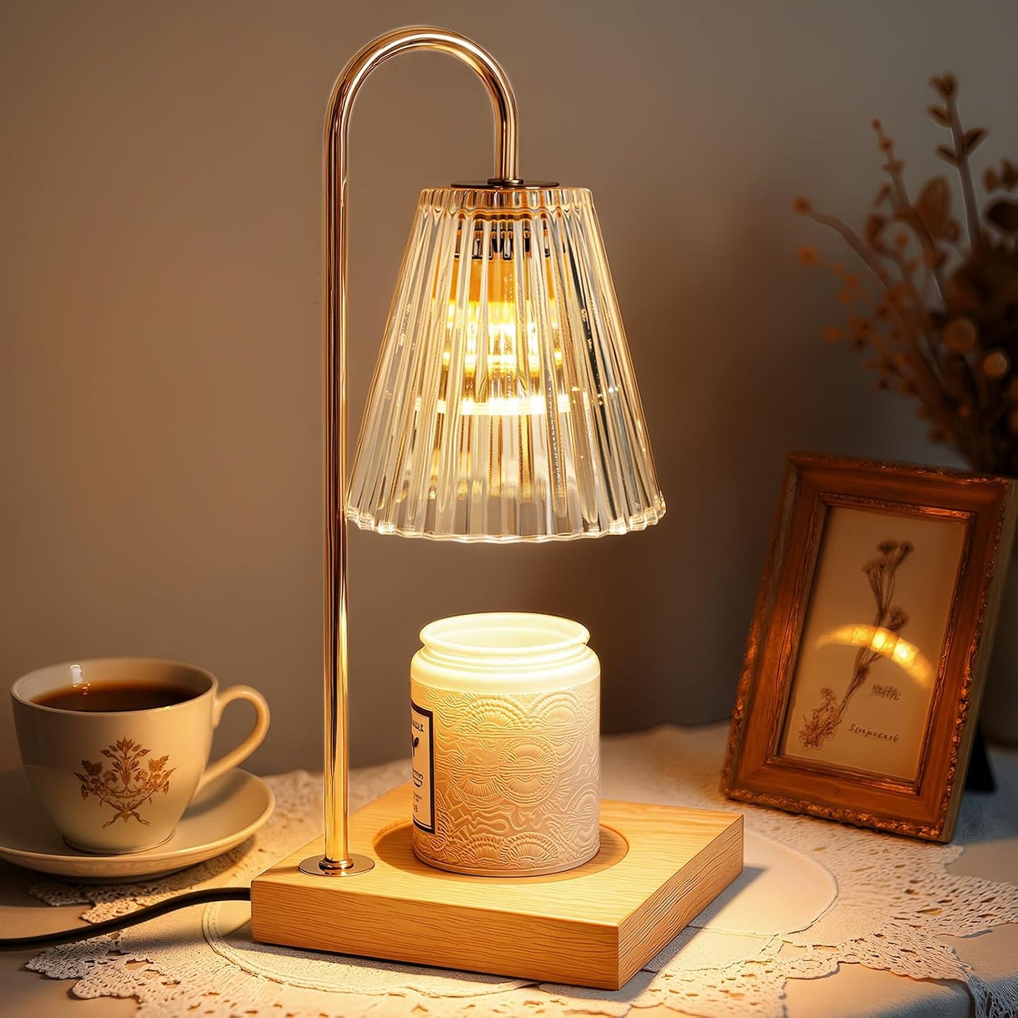 Gold candle warmer lamp beside a coffee cup and picture frame