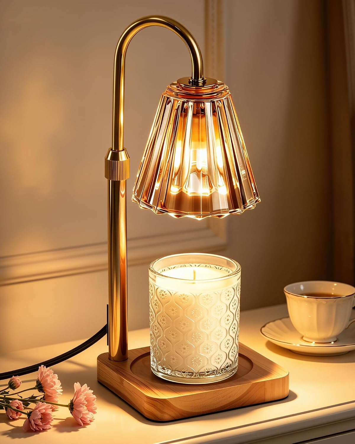 Gold candle warmer lamp glowing on a bedside table